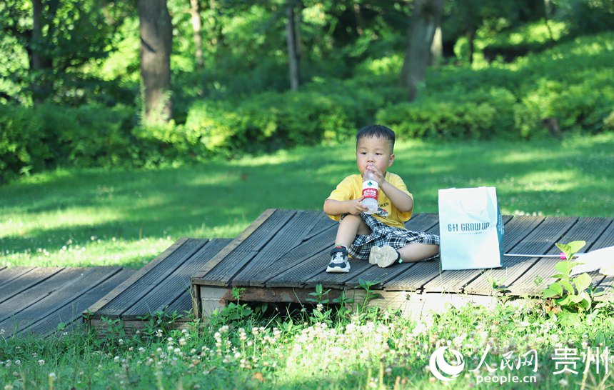 在阿哈湖公園內小男孩在喝水。人民網 顧蘭云攝