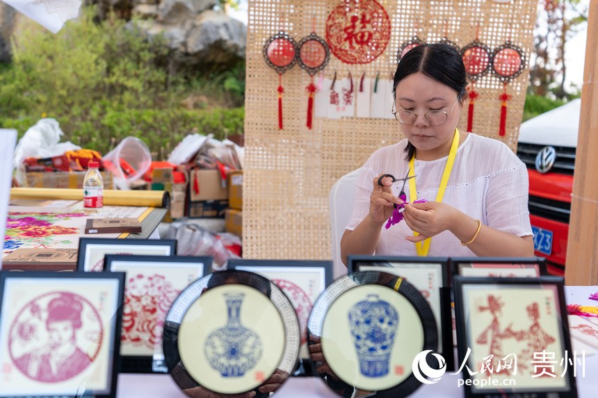 山地生活消費(fèi)與非遺傳承展現(xiàn)場(chǎng)，非遺技藝剪紙傳承人展示剪紙技藝。人民網(wǎng) 涂敏攝