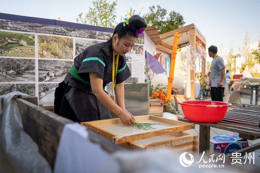 山地生活消費與非遺傳承展現(xiàn)場，非遺技藝丹寨古法造紙傳承人展示古法造紙技藝。人民網(wǎng) 涂敏攝