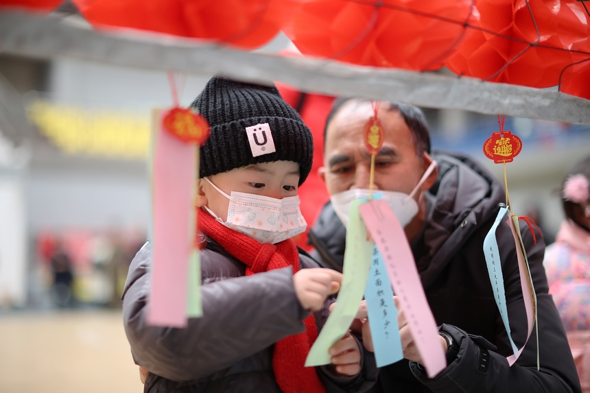 2月2日，小朋友在家長的指導下猜燈謎。