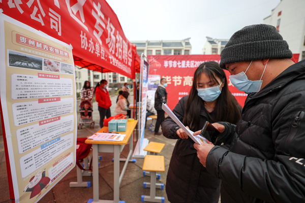 在七星關(guān)區(qū)歸化街道生態(tài)移民安置點(diǎn)招聘會現(xiàn)場 企業(yè)工作人員正在向搬遷群眾介紹薪資待遇。張怡婷攝