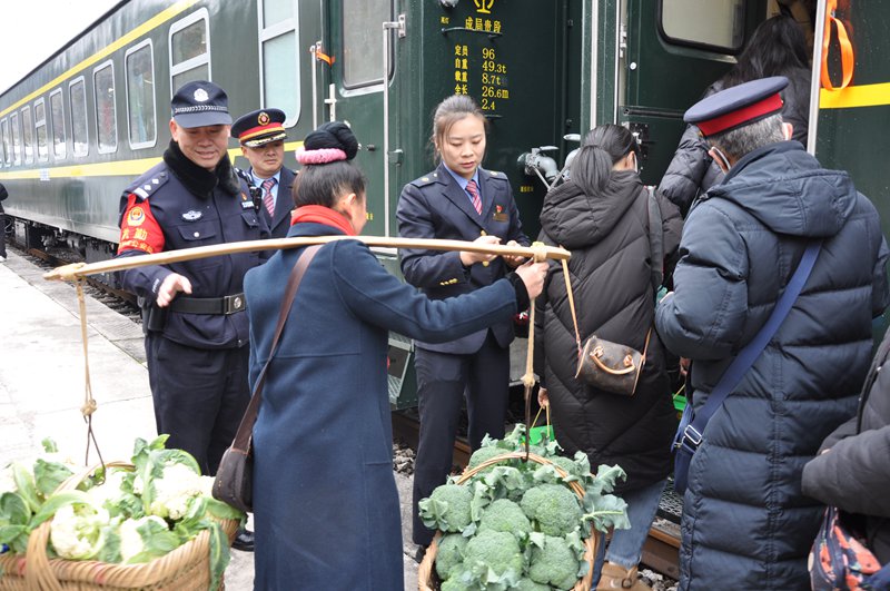 列車員幫著村民一同挑貨上車。楊道軍 攝