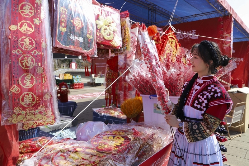 少數(shù)民族同胞正在挑選年貨。管慶巍攝