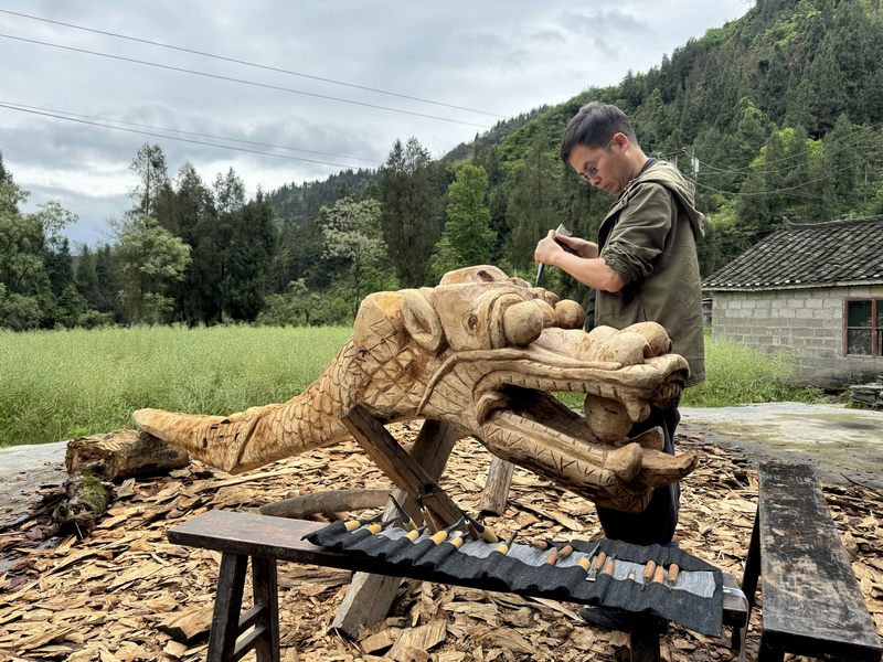 近日，碧江區(qū)和平鄉(xiāng)陳家寨村村民在制作龍舟龍頭，為端午節(jié)龍舟賽做準(zhǔn)備。 申逸愷攝