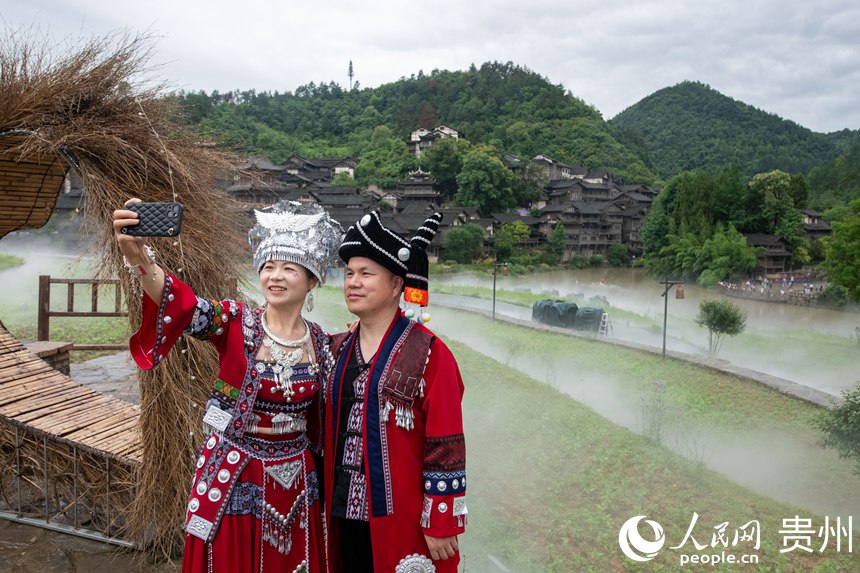 6月24日，來自浙江溫州的陳先生夫婦在烏江寨景區(qū)自拍留念。人民網(wǎng)記者 翁奇羽攝