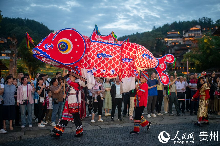 6月24日，在烏江寨景區(qū)，傳統(tǒng)民俗表演吸引眾多游客駐足觀賞。人民網(wǎng)記者 翁奇羽攝